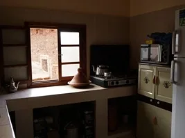 La cuisine du gîte avec plaques de gaz, réfrigérateur et vaisselle